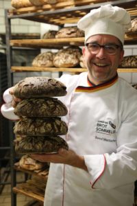 Brot-Sommelier Bernd Wettlaufer mit Broten in der Hand.