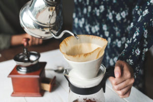 Kaffee aufgießen mit heißem Wasser und einem Kaffeefilter, Kaffeemühle