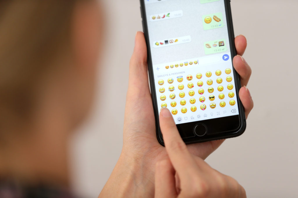 Ein Finger, der auf einen Handybildschirm zeigt, auf dem eine App geöffnet ist
